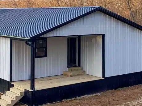 30x70 white and black trimmed barndominium with side entrance with porch and black metal roofing