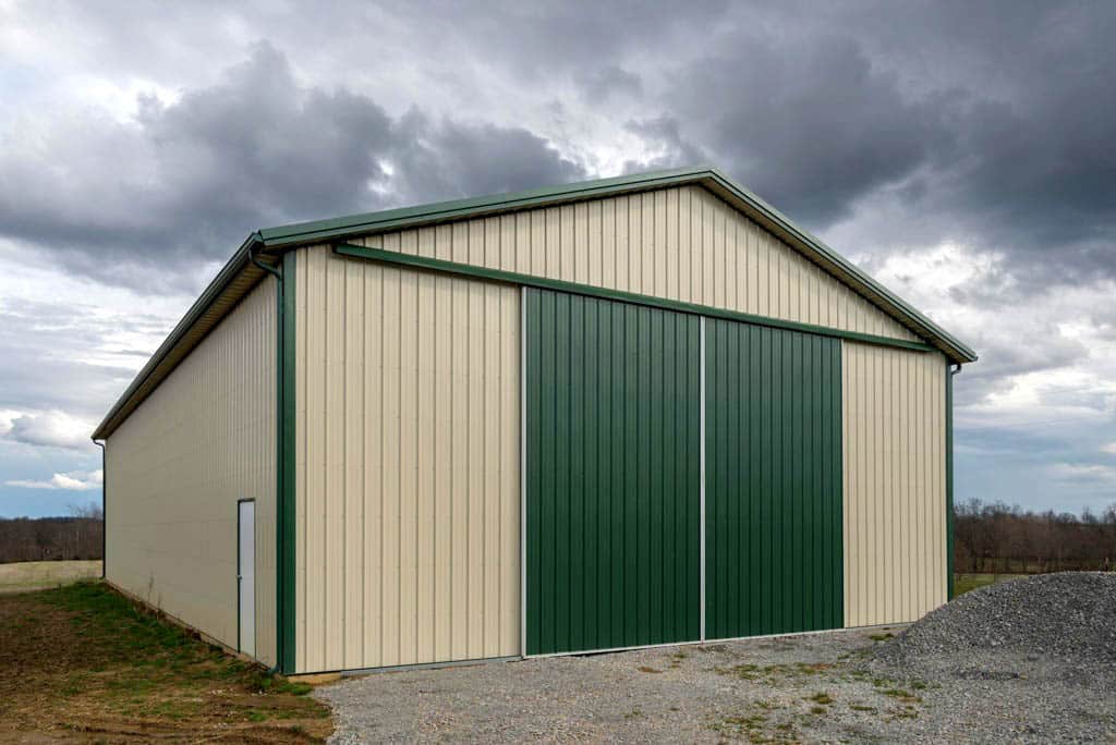 40x64 agricultural pole barn with tan siding green trim roof and siding