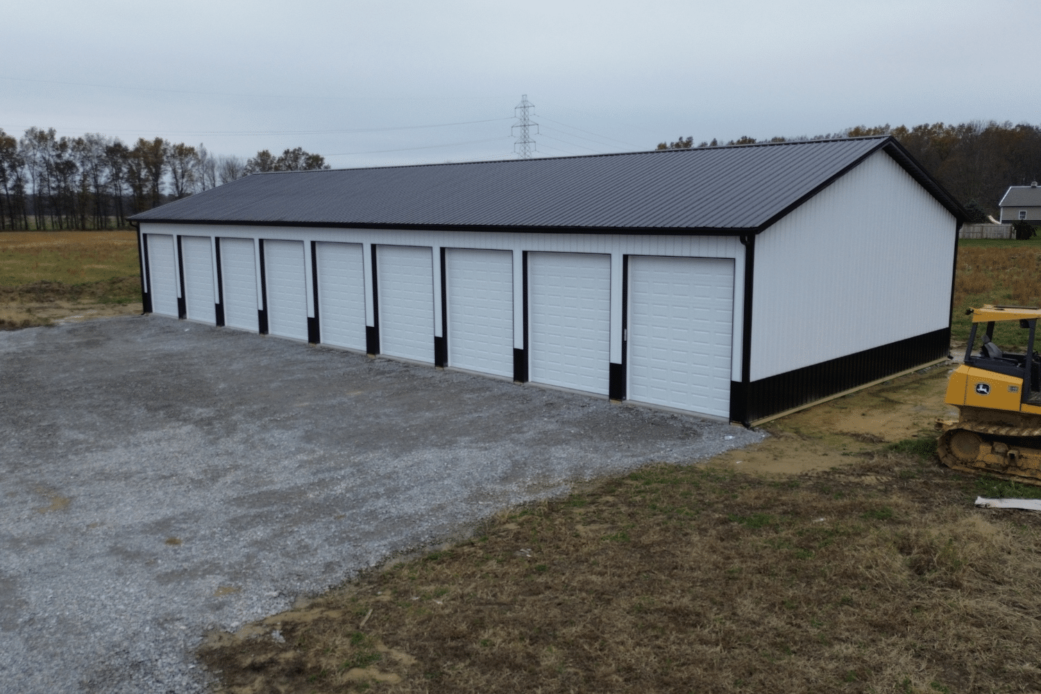 50x70 white garage pole barn kit with black roof and nine white garages