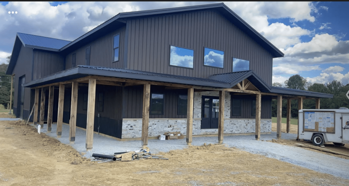 A black 80x120 commercial pole barn with a porch
