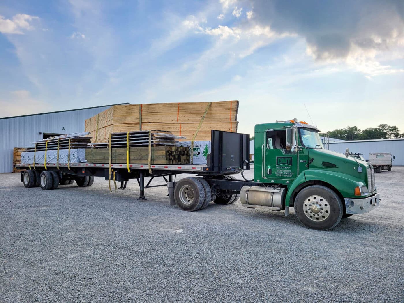 roof trusses being delivered on back of green truck