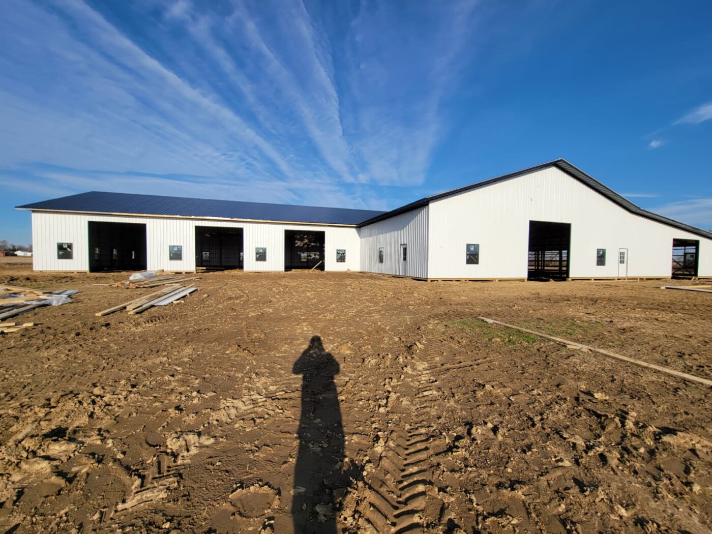 white pole barn with black metal roof and no doors