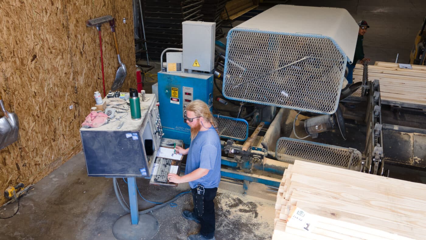 aerial view of man programming computer to cut wooden roof trusses to the specifications of a 30x50 commercial pole barn project