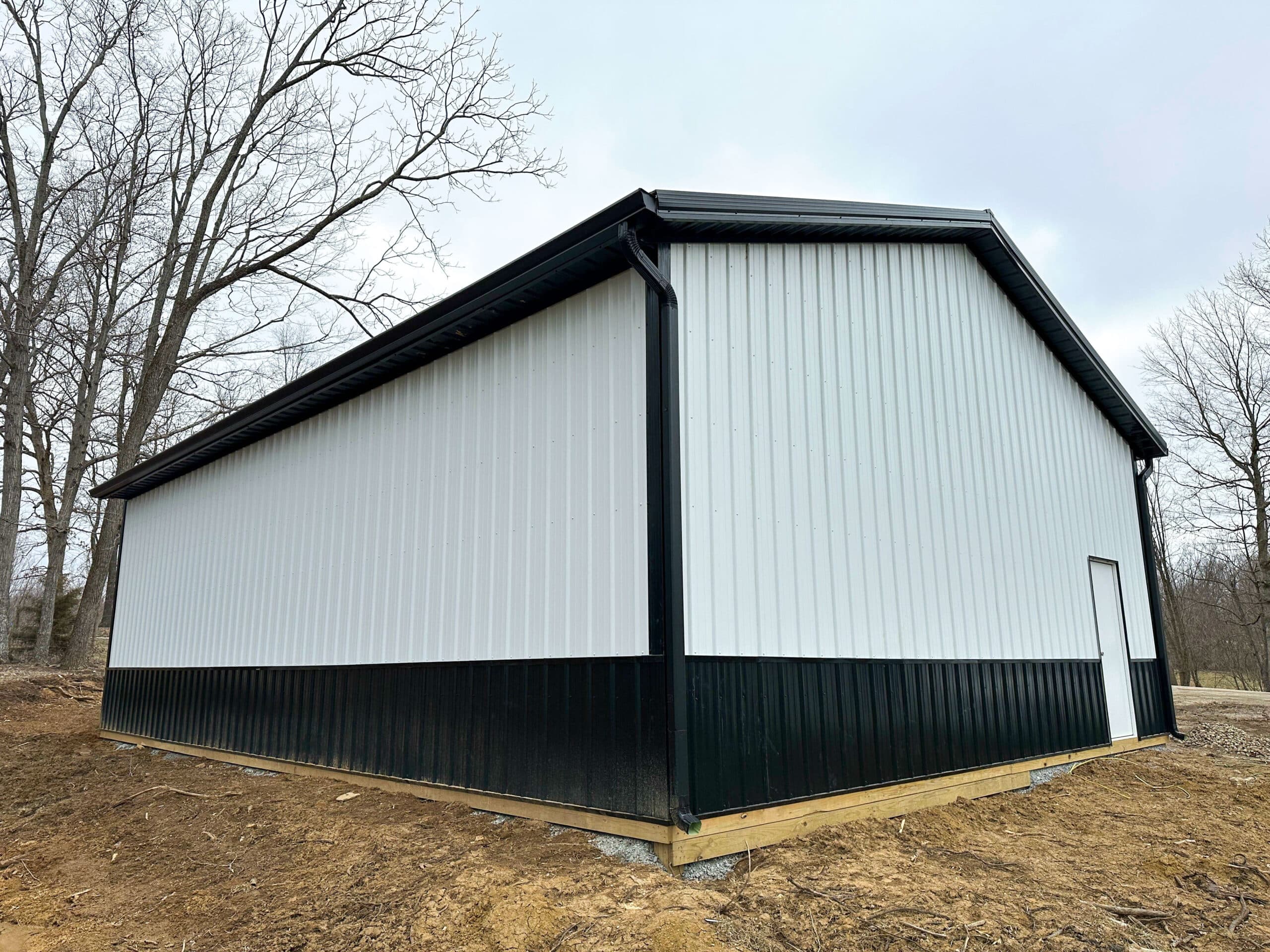 back view of white and black trimmed pole barn