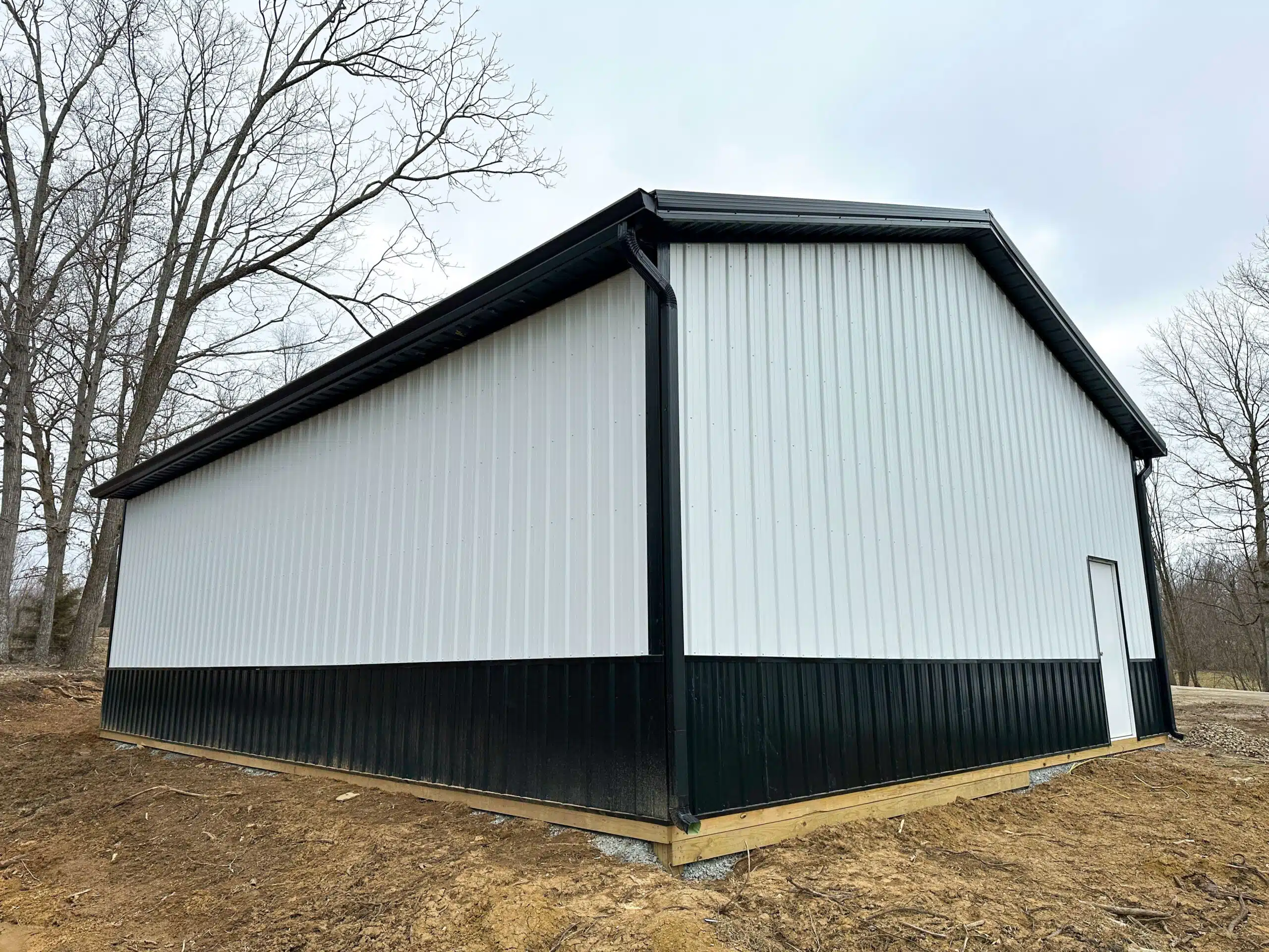 back view of white and black trimmed pole barn