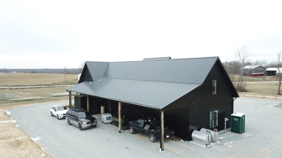 a black metal 30x100 barndominium on a cloudy day
