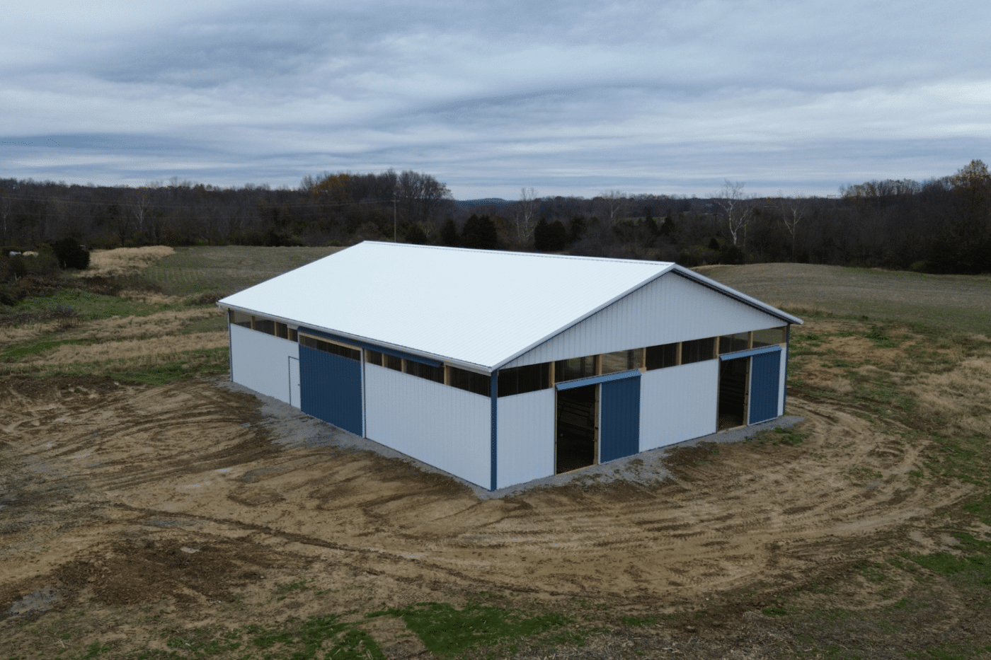blue and white 60x100 agricultural pole barn kit with doors and white metal roof