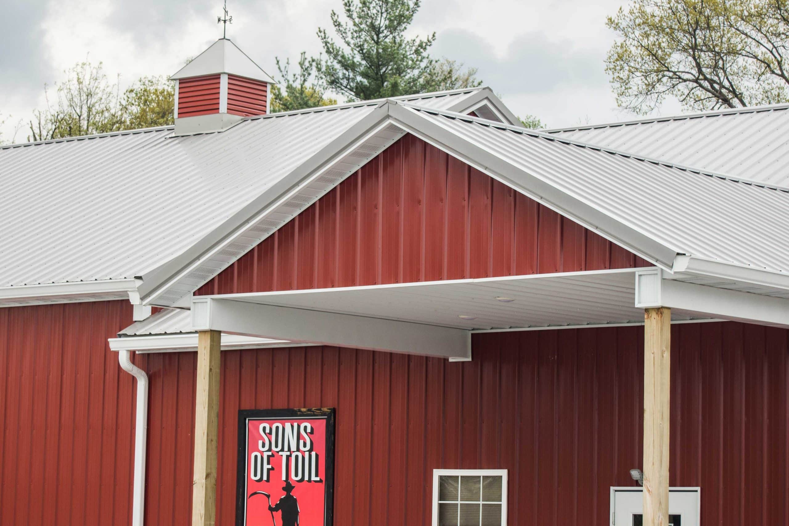 Red 24x36 commercial pole barn with a white roof