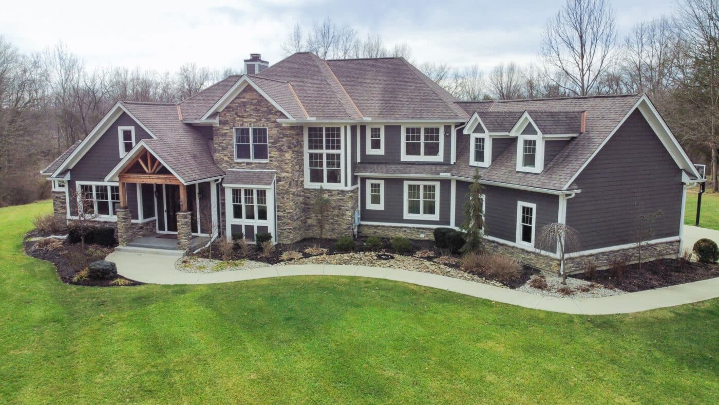 dark gray barndominium with stone deatiling and white trim