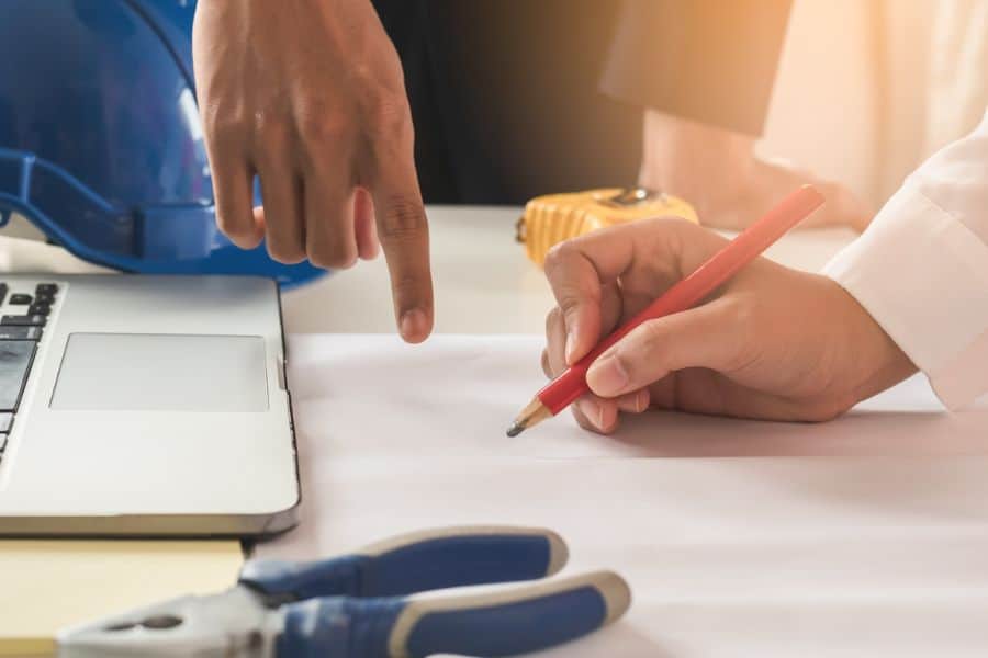 two people planning and drawing a design on a white sheet of paper