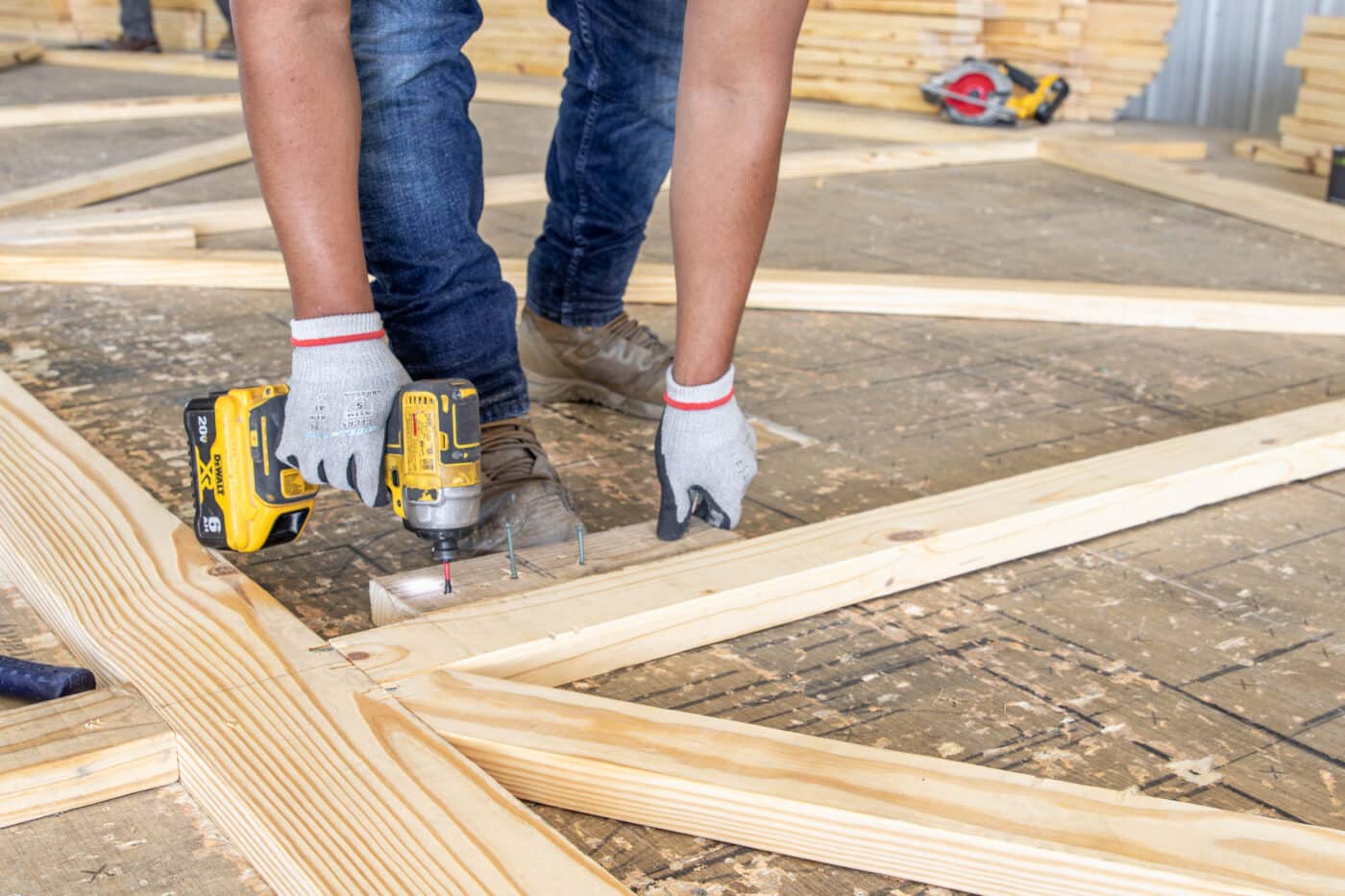 A man drilling into a roof truss for a 30x40 equestrian pole barn