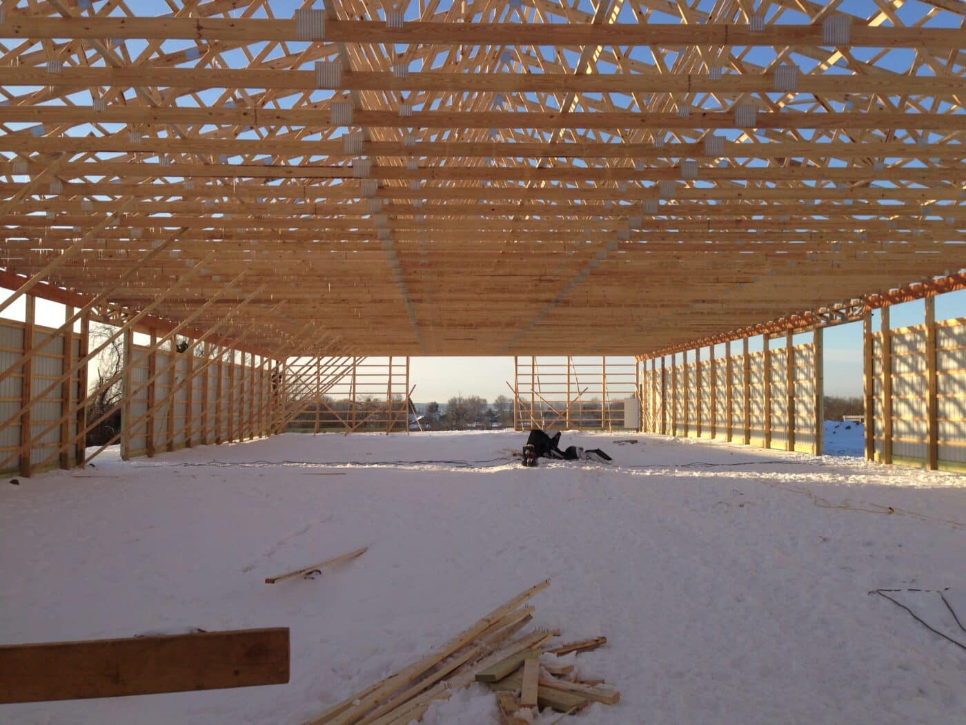 wooden roof trusses visible from the inside of a 80x90 pole barn garage