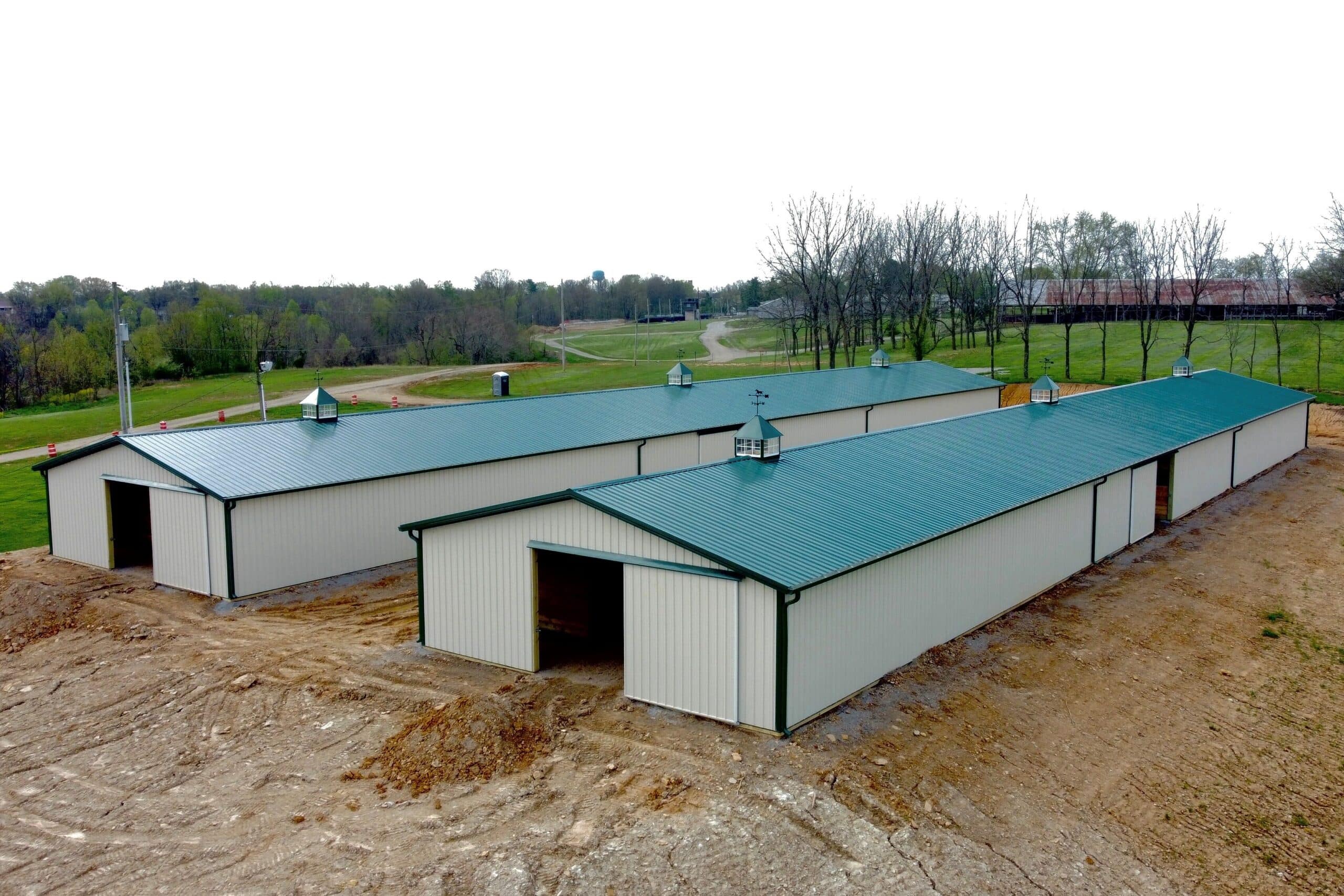 front view of tan and green equestrian pole barns