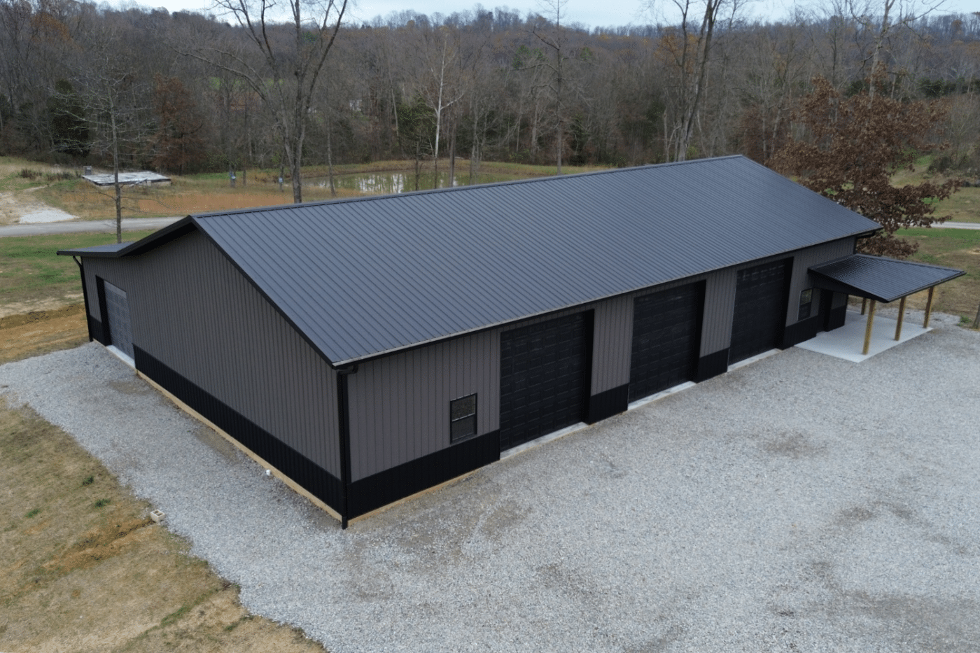 gray 50x70 garage pole barn kit with black metal roof and three black garages