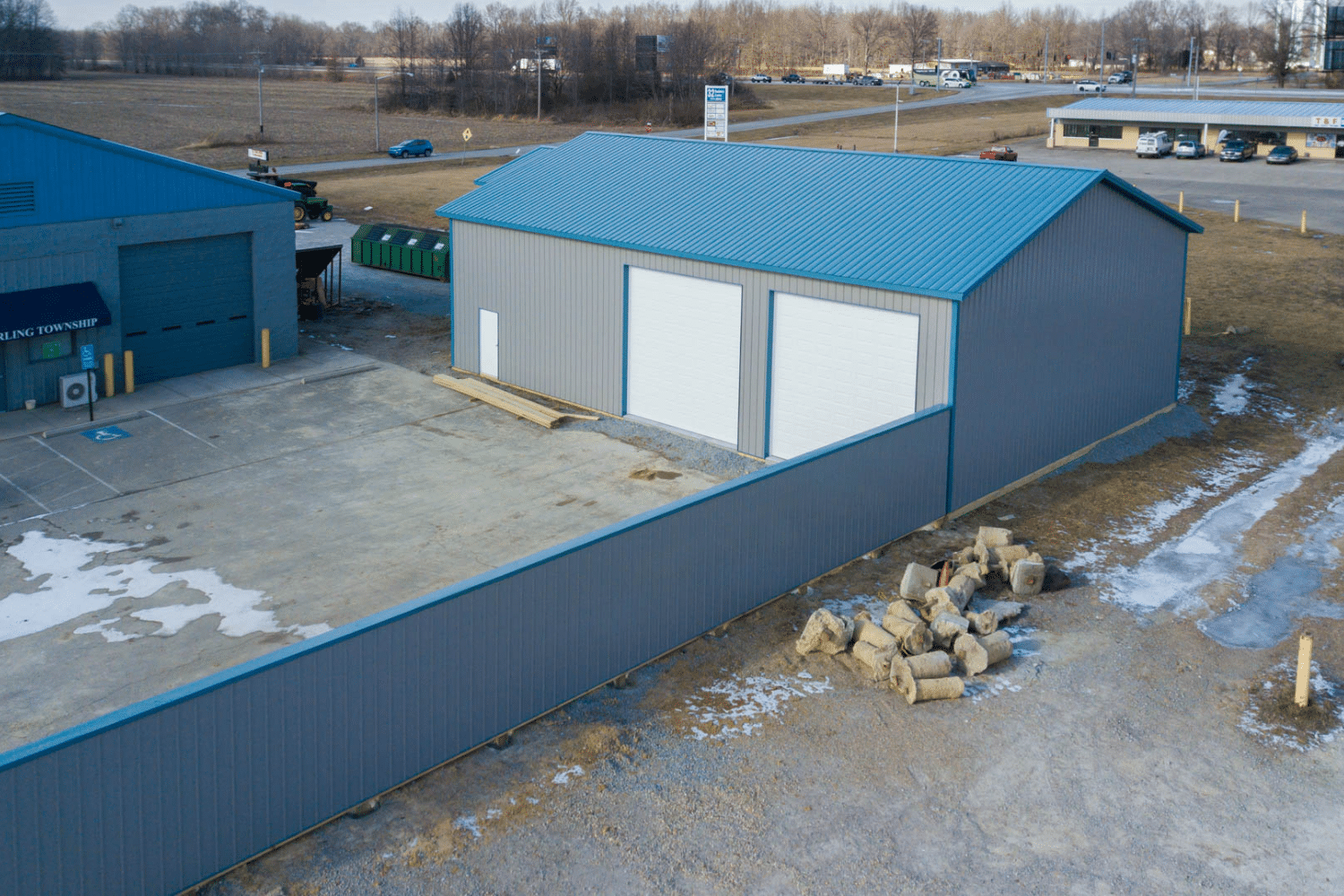 gray and blue 60x90 commercial pole barn kit with two garages and fence