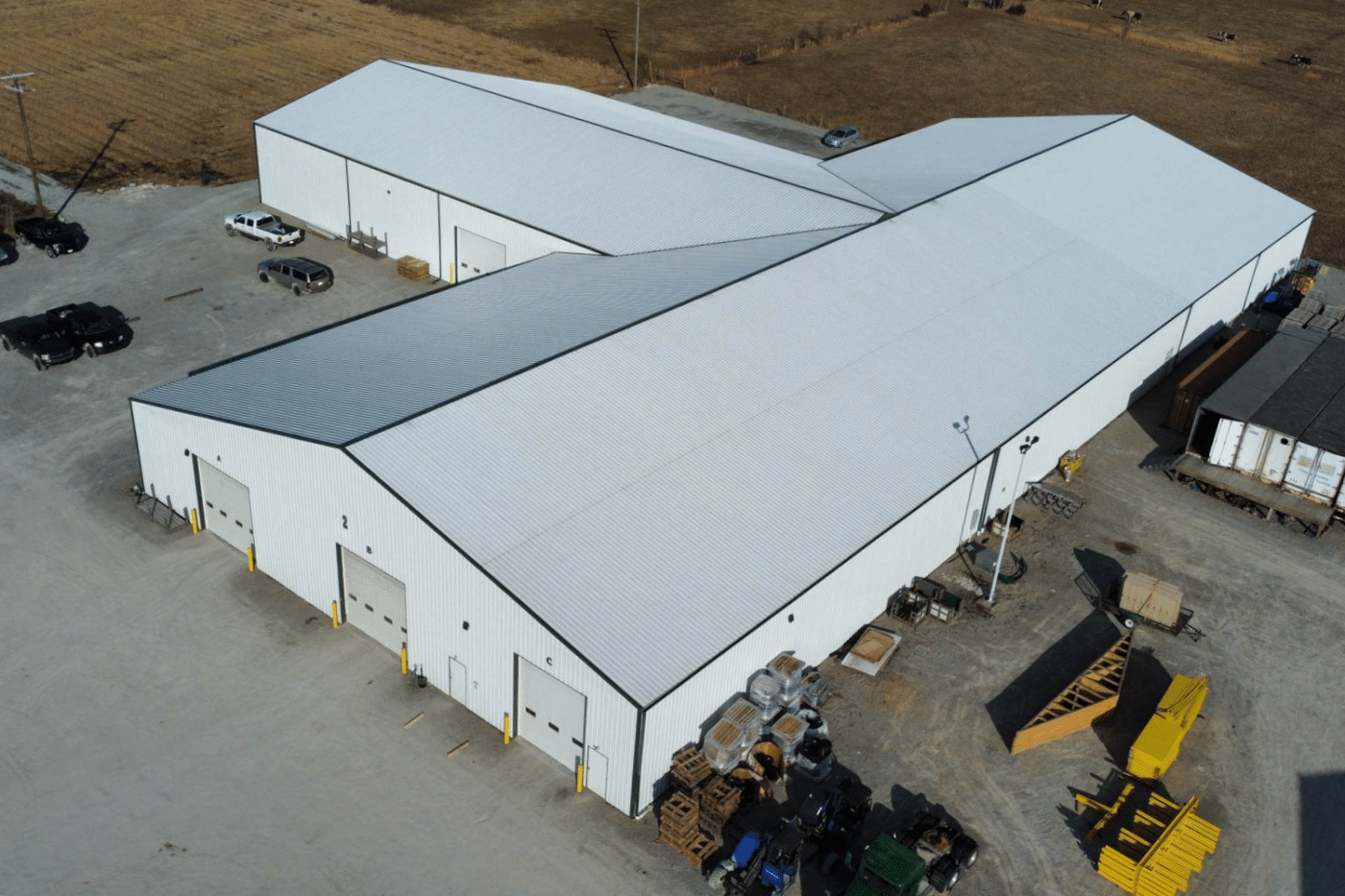 white garage pole barn kit with many white garages and gray metal roof