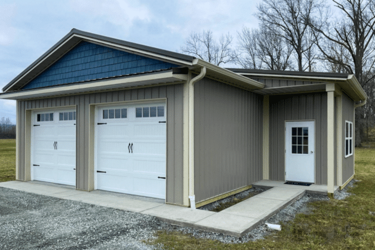 gray sided 24x28 garage pole barn with blue detailing and white overhead doors with transom windows