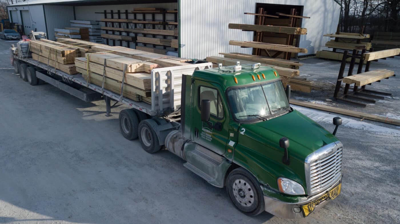 green truck with wood strapped to the back