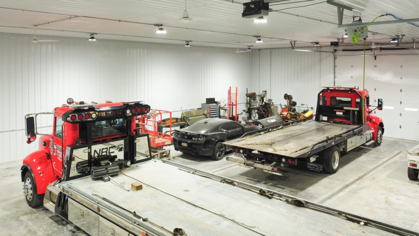 interior of a commercial pole barn garage featuring trucks car and tools