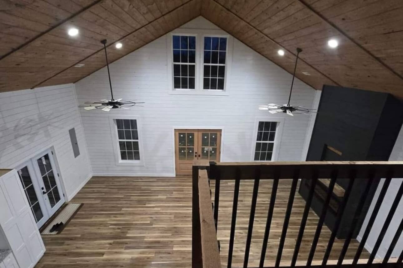 interior of barndominium featuring insulated walls windows flooring and roofing