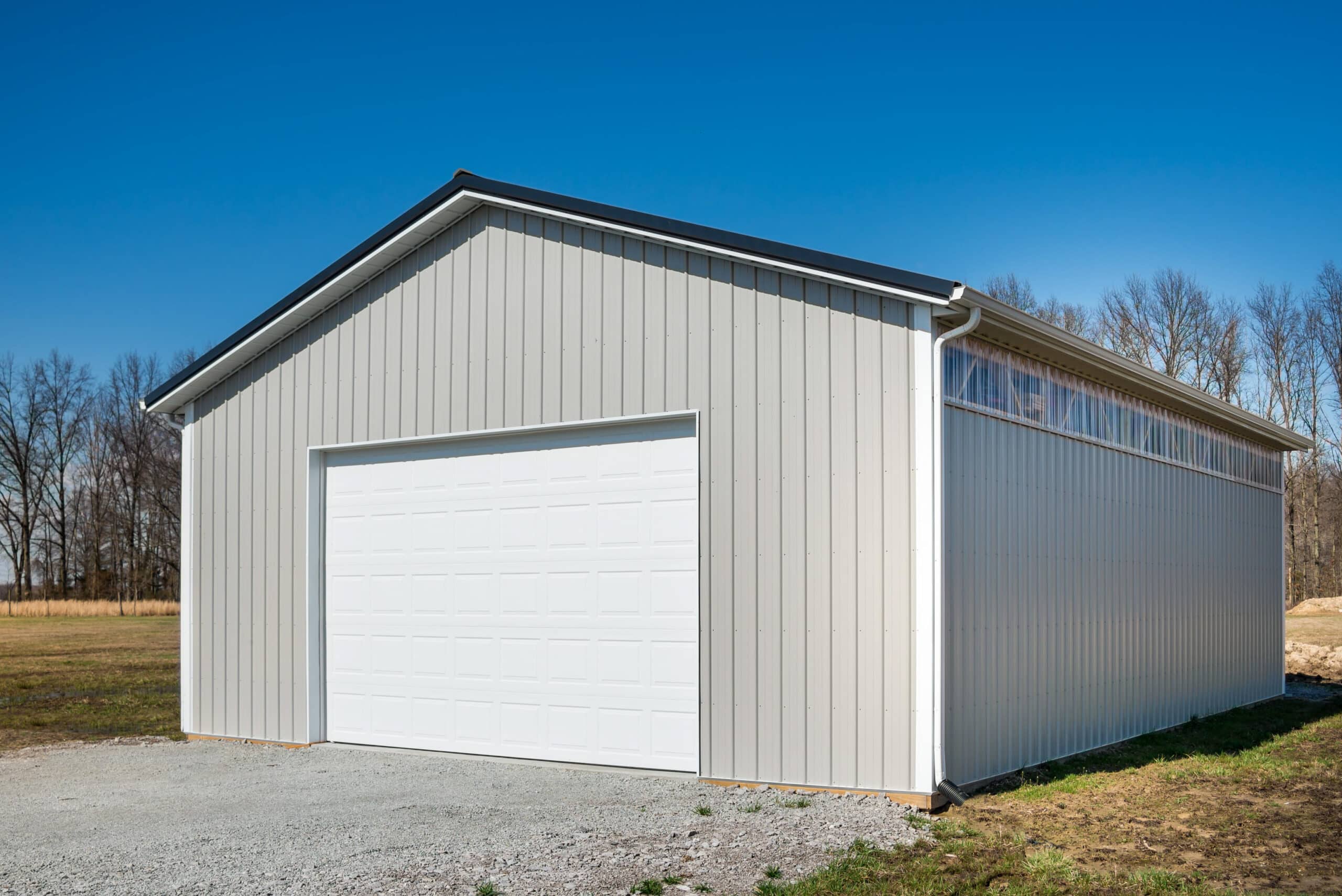 ight gray garage pole barn kits in Lebanon OH with clear upper siding and one white overhead door