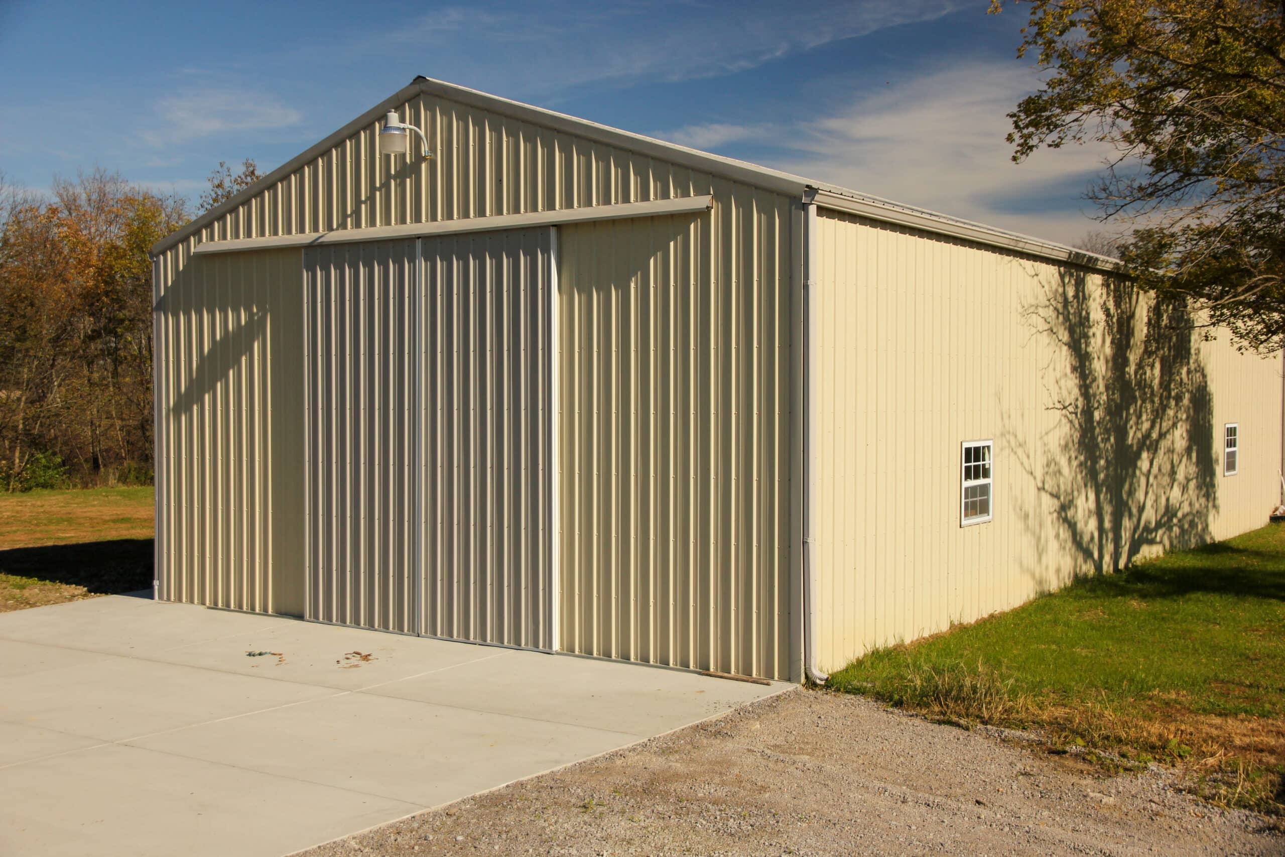 light yellow 24x24 garage pole barn with white slider doors