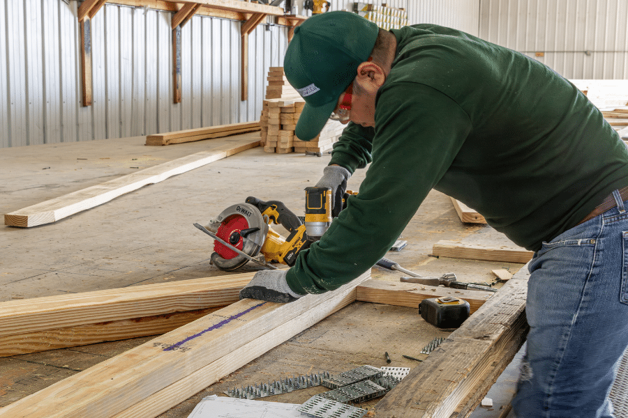 man assembling roof trusses for a barndominimum kit