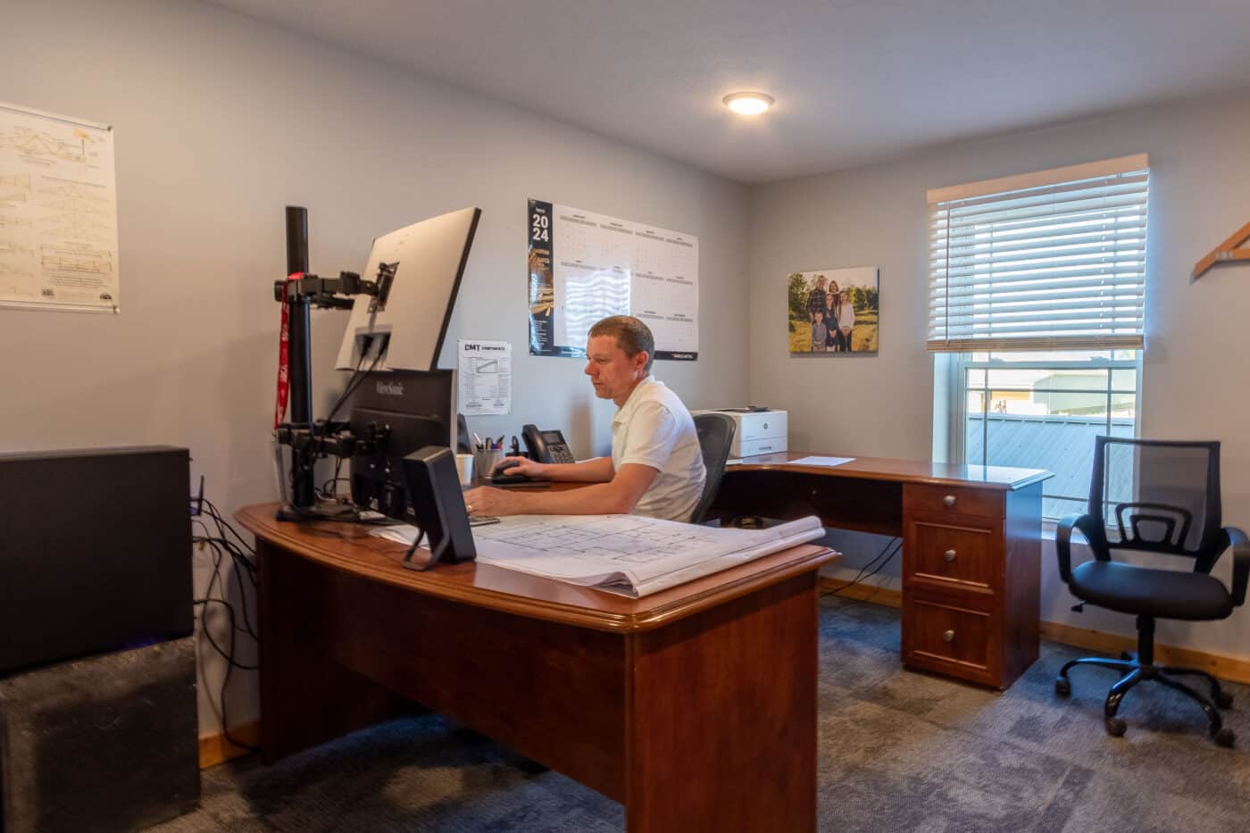man at his desk on computer by phone