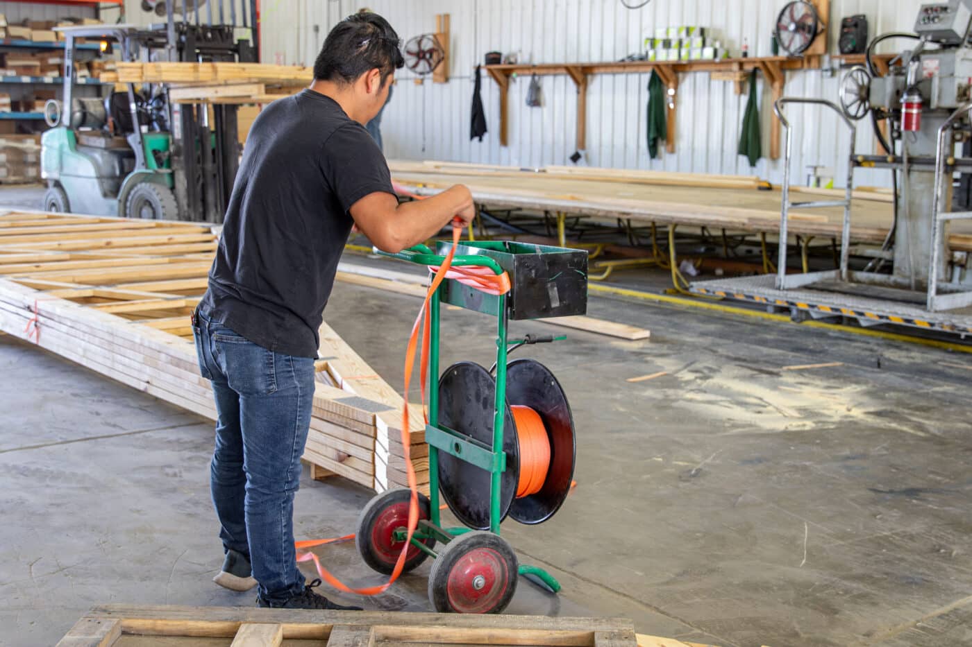 man getting orange ties to put together order of roof trusses for 30x60 commercial pole barn