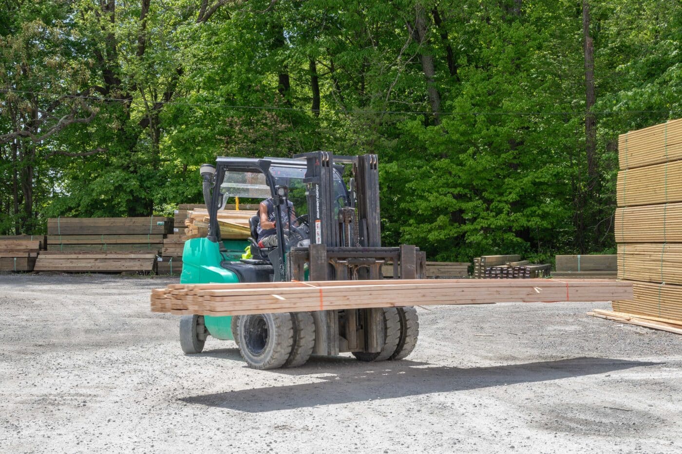 man moving lumber for pole barn kits