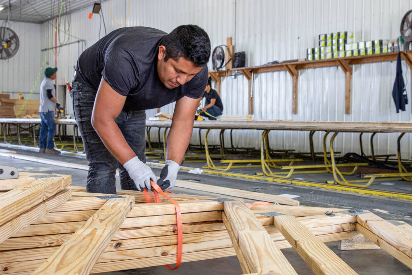 man tying together order of roof trusses for 30x33 pole barn garage