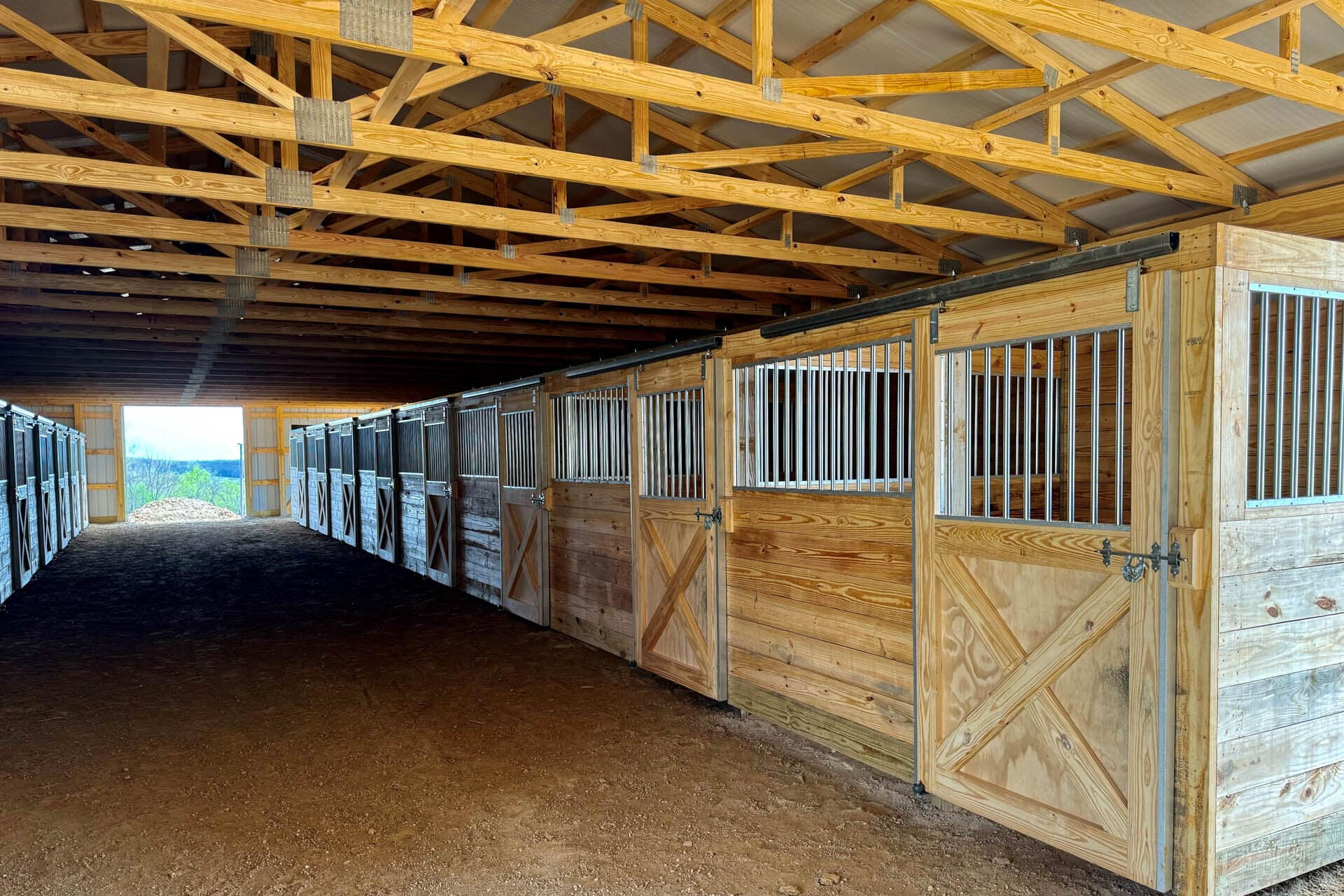 multiple wooden stalls inside a 60x60 equestrian pole barn