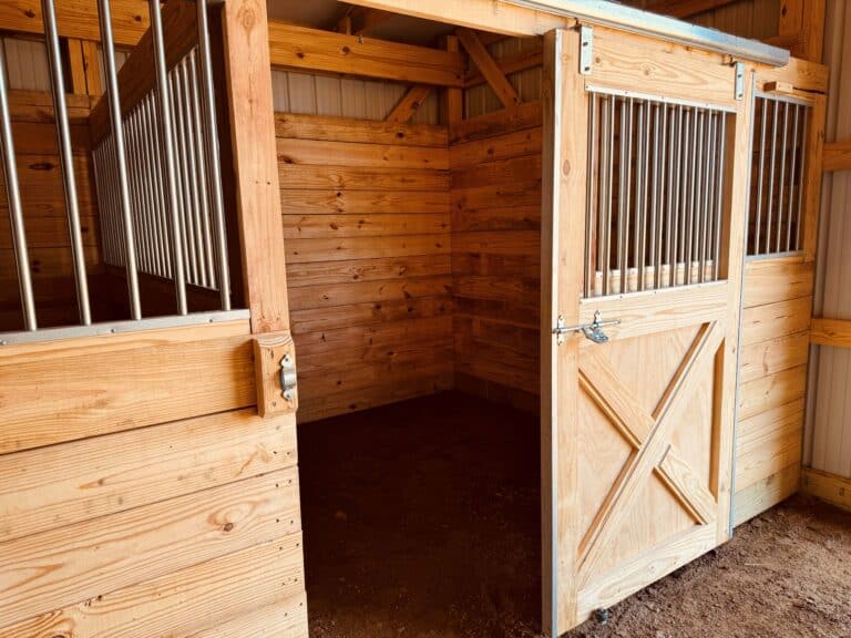 one wooden stall inside an equestrian pole barn