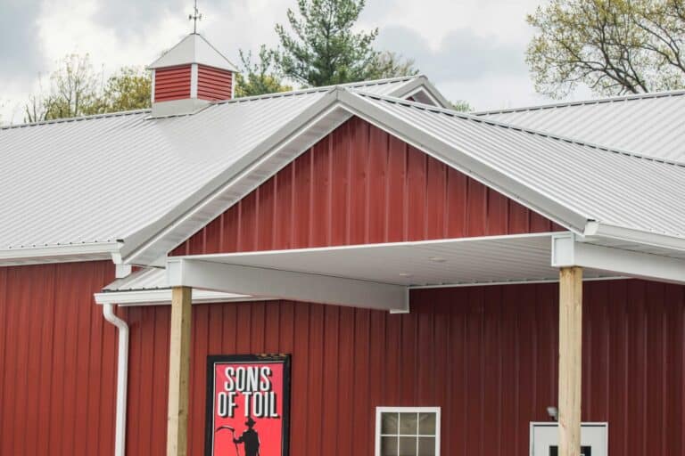 A red 150x200 commercial pole barn with a white roof