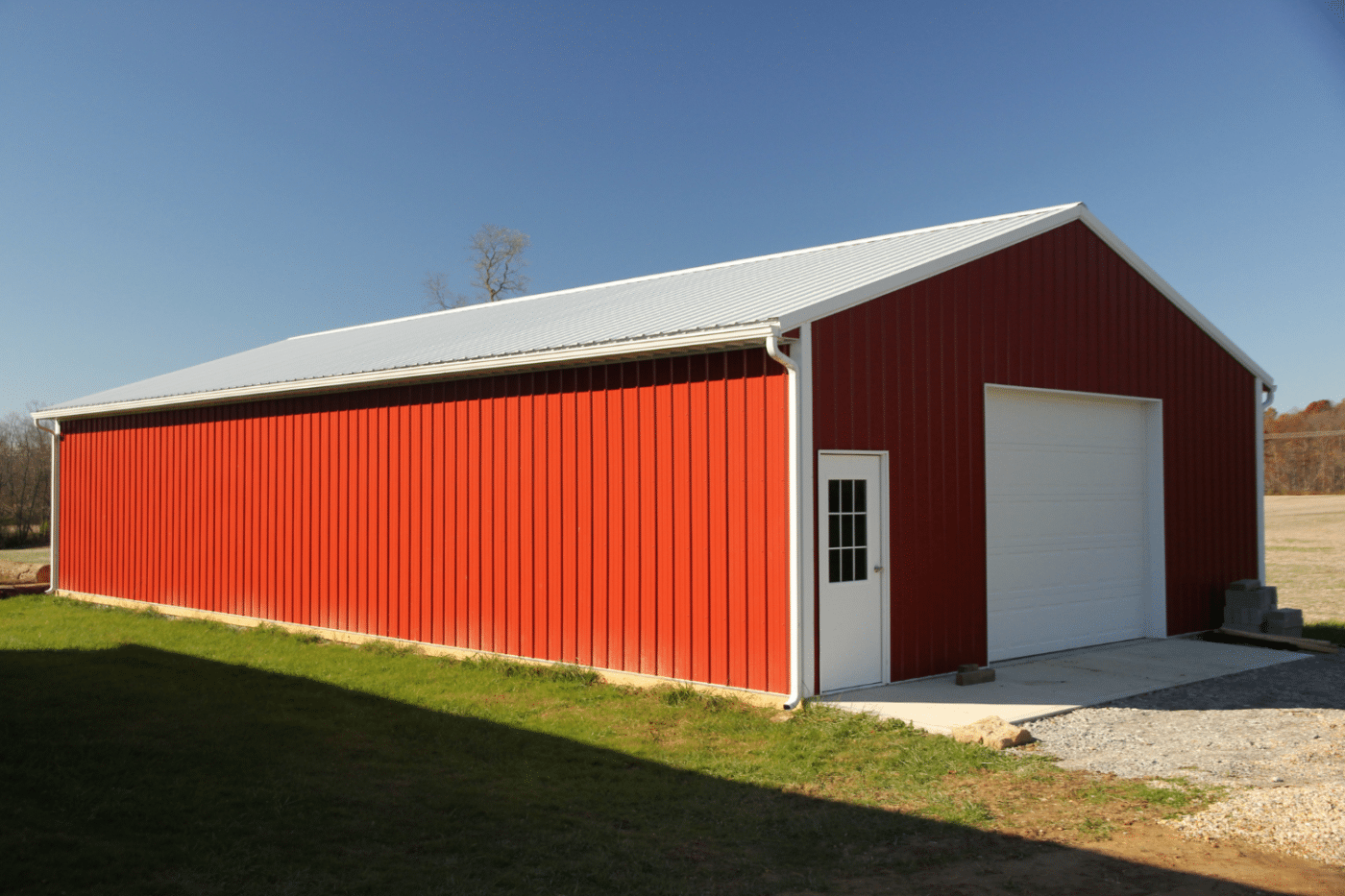 red 50x70 garage pole barn kit with white roof and white garage