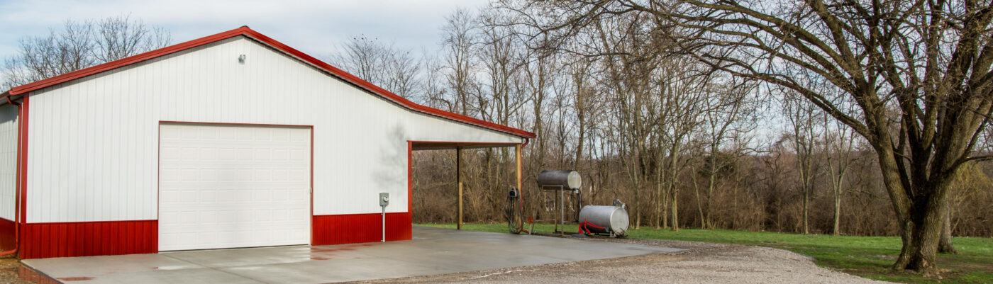 red and white metal siding on pole barn with white side overhead door