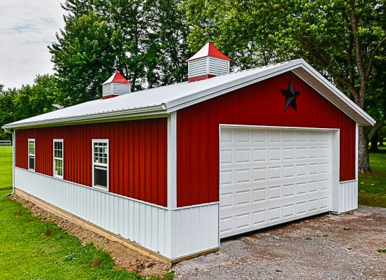 red pole barn garage with white metal panels along bottom and white trim featuring white metal roof with two cupolas and black star above garage door