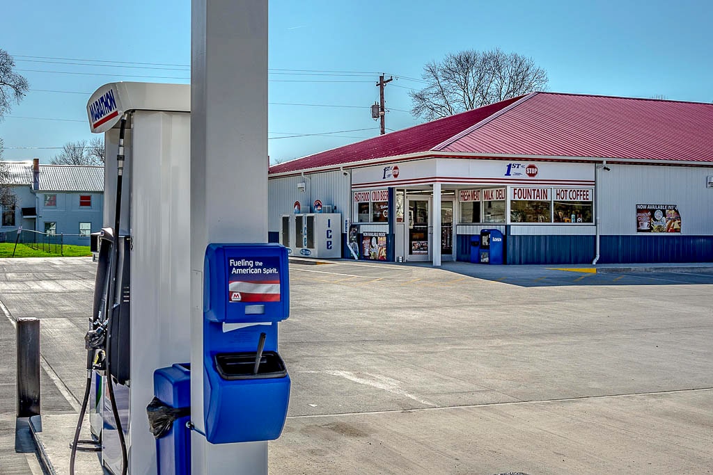 red white and blue metal commercial pole barn serving as conveinence store/gas station by gas pumps