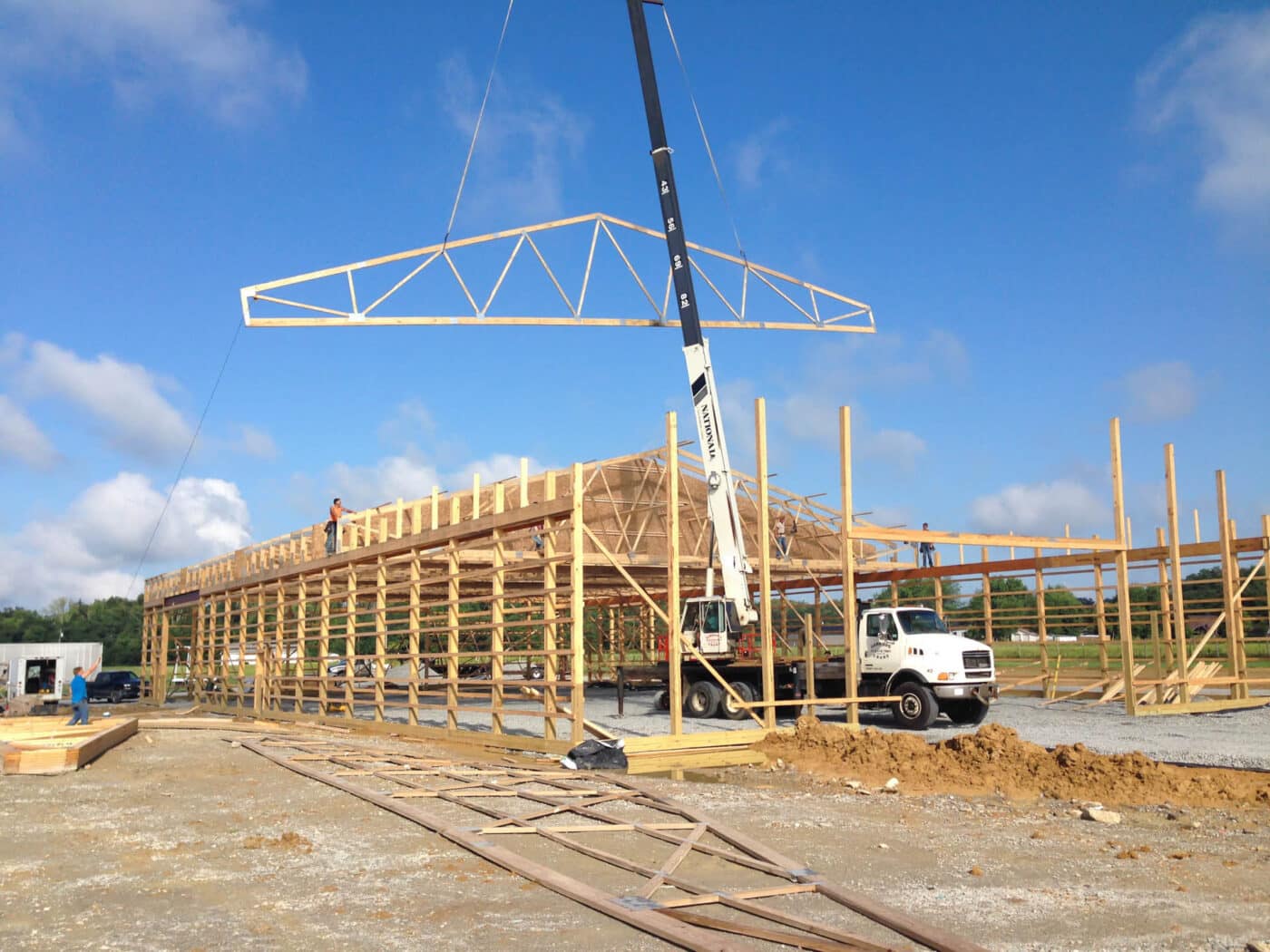 roof truss being lowered onto pole barn