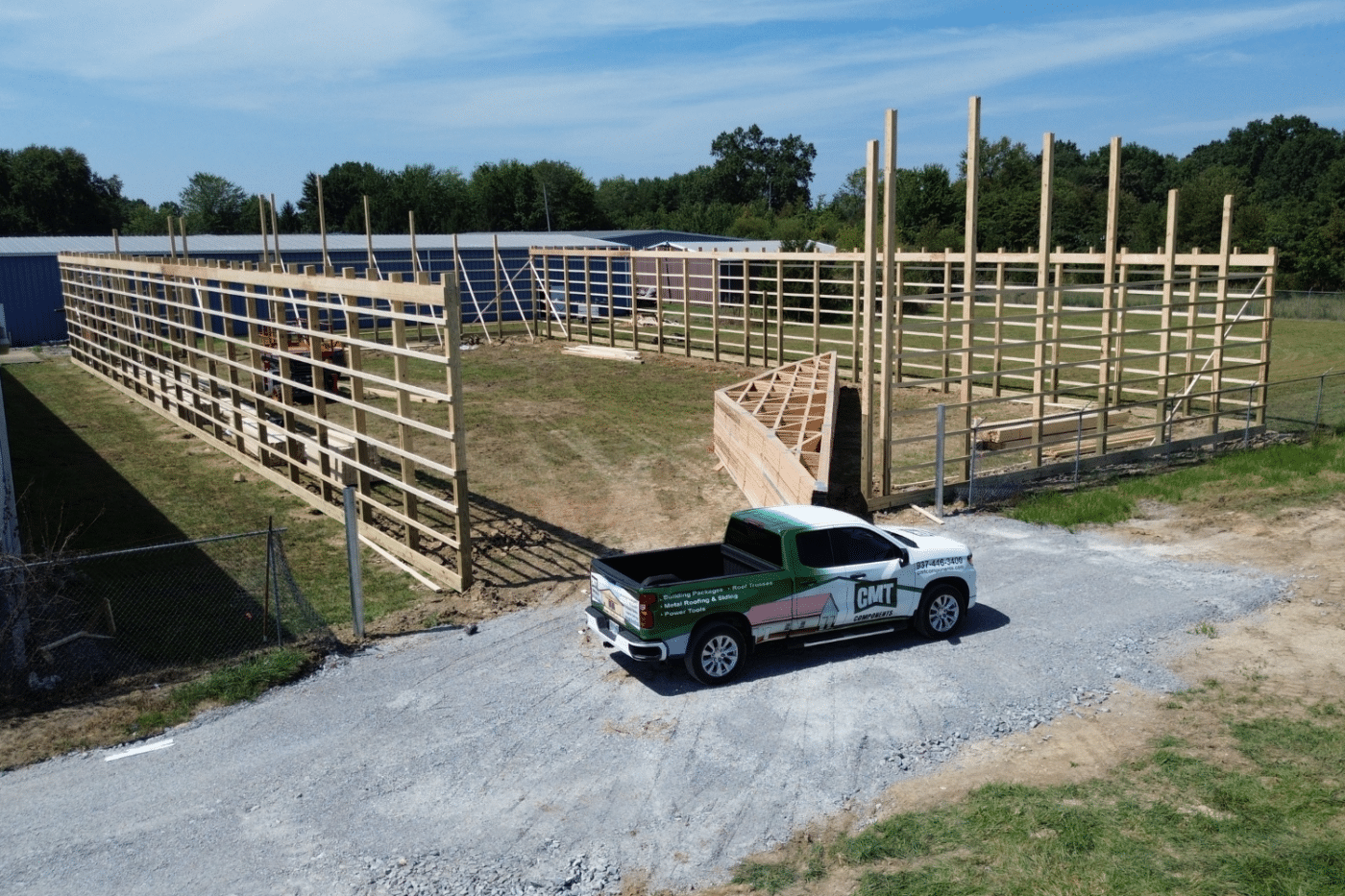 roof trusses on construction site for 80x120 garage pole barn kit with truck parked
