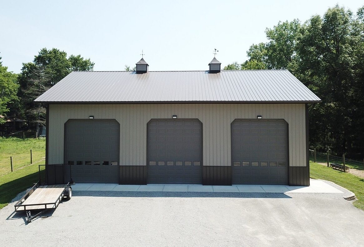 tan 3 car pole barn garage in New Richmond OH with three brown garage doors