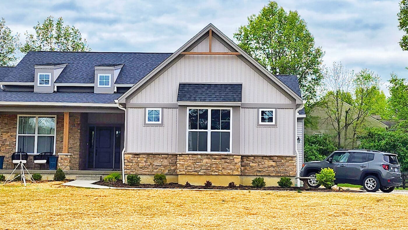 tan and gray shingles on barndominium with stone detailing