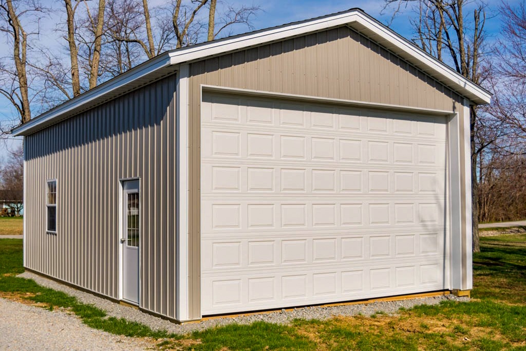 tan metal pole barn garage with white trim and white overhead garage door