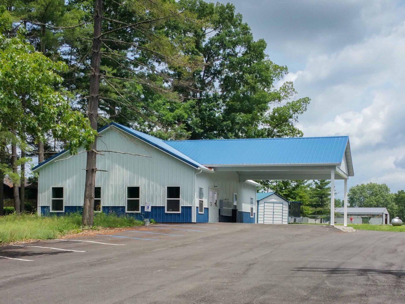 white 50x100 commercial pole barn with blue trim and a blue metal roof