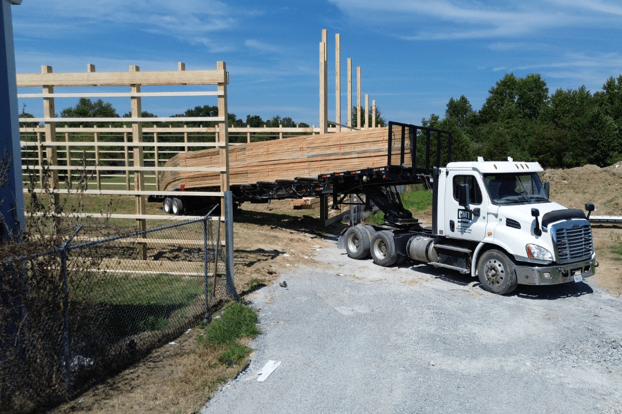 white CMT truck dropping off roof trusses to pole barn project