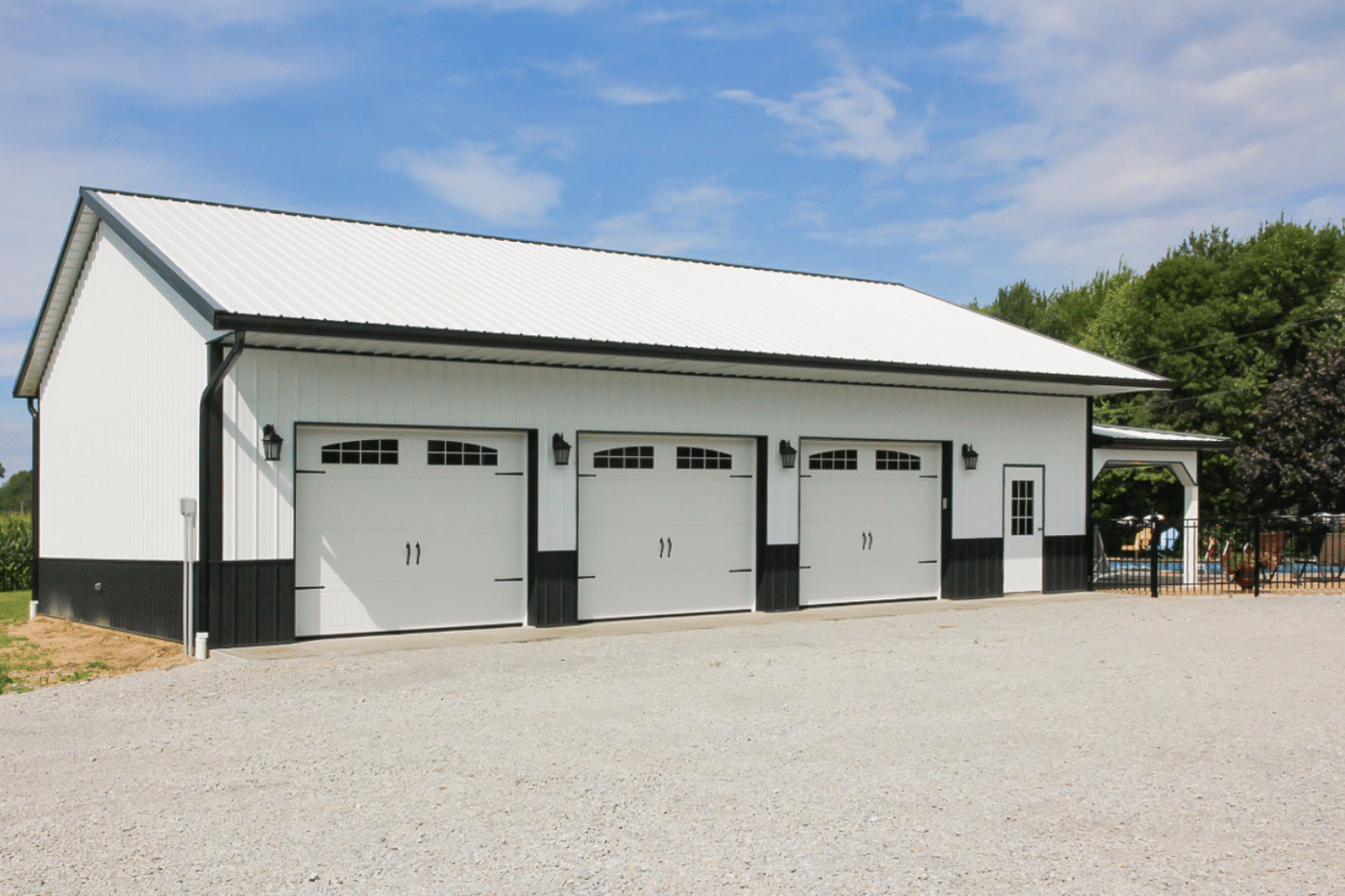 white and black 100x100 barndominium with three white garages