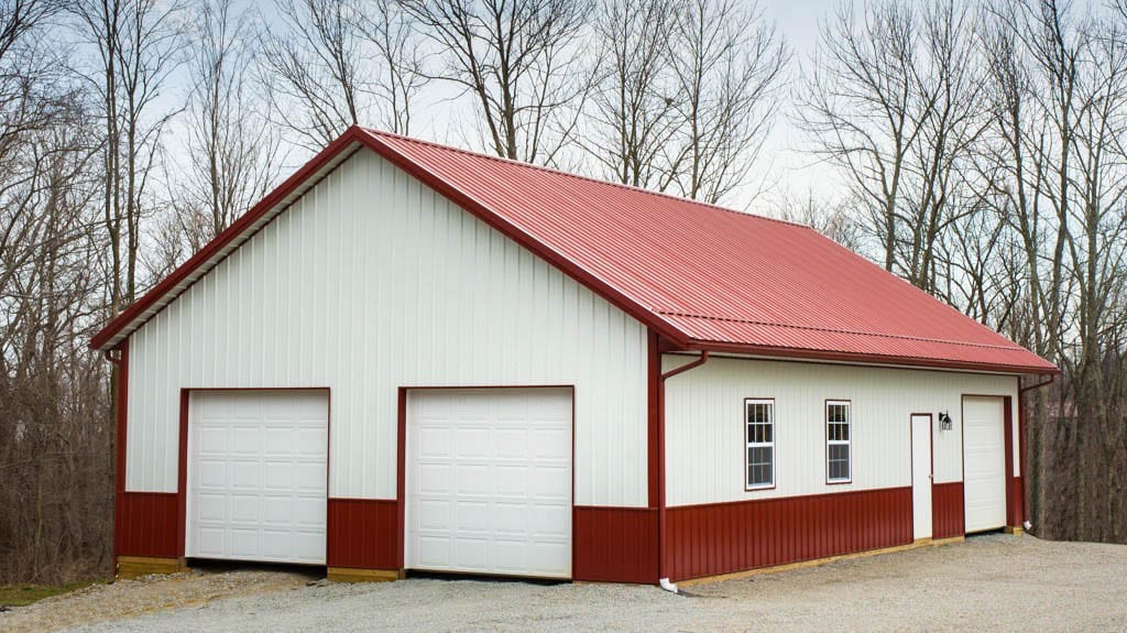 white and red trimmed 30x33 pole barn garage with two white garage doors