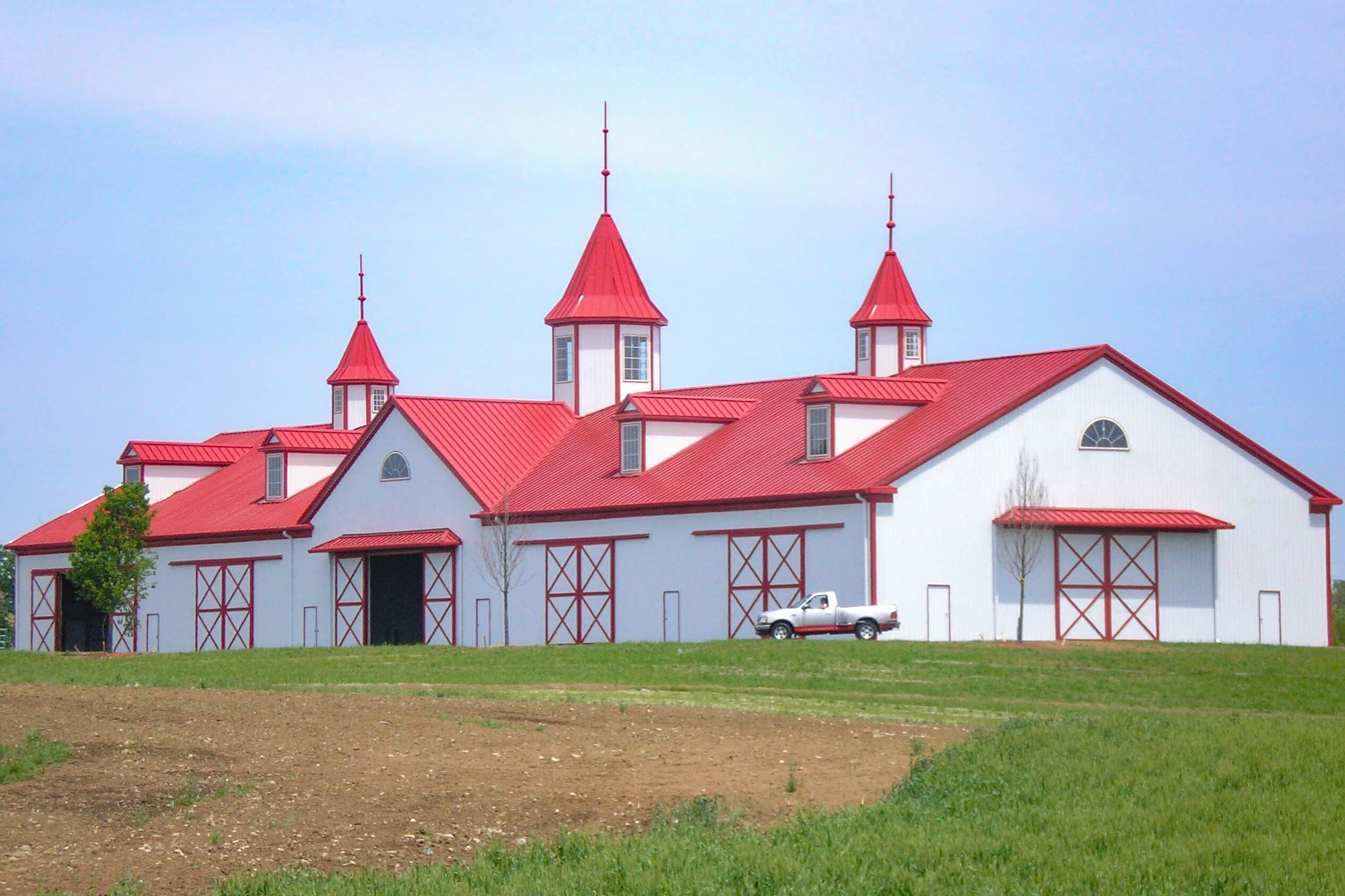 white and red trimmed agricultural poole barn kits in Newport OH with red metal roof