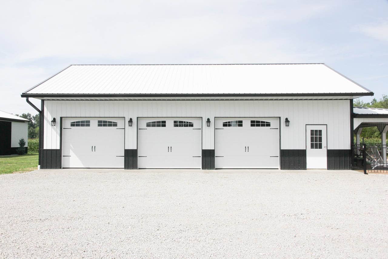 White pole barn garage with dark trim and three garage doors in Hillsboro OH