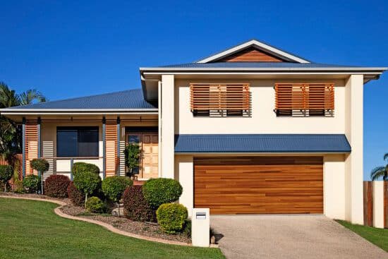 wooden garage door on white home with wooden detailing